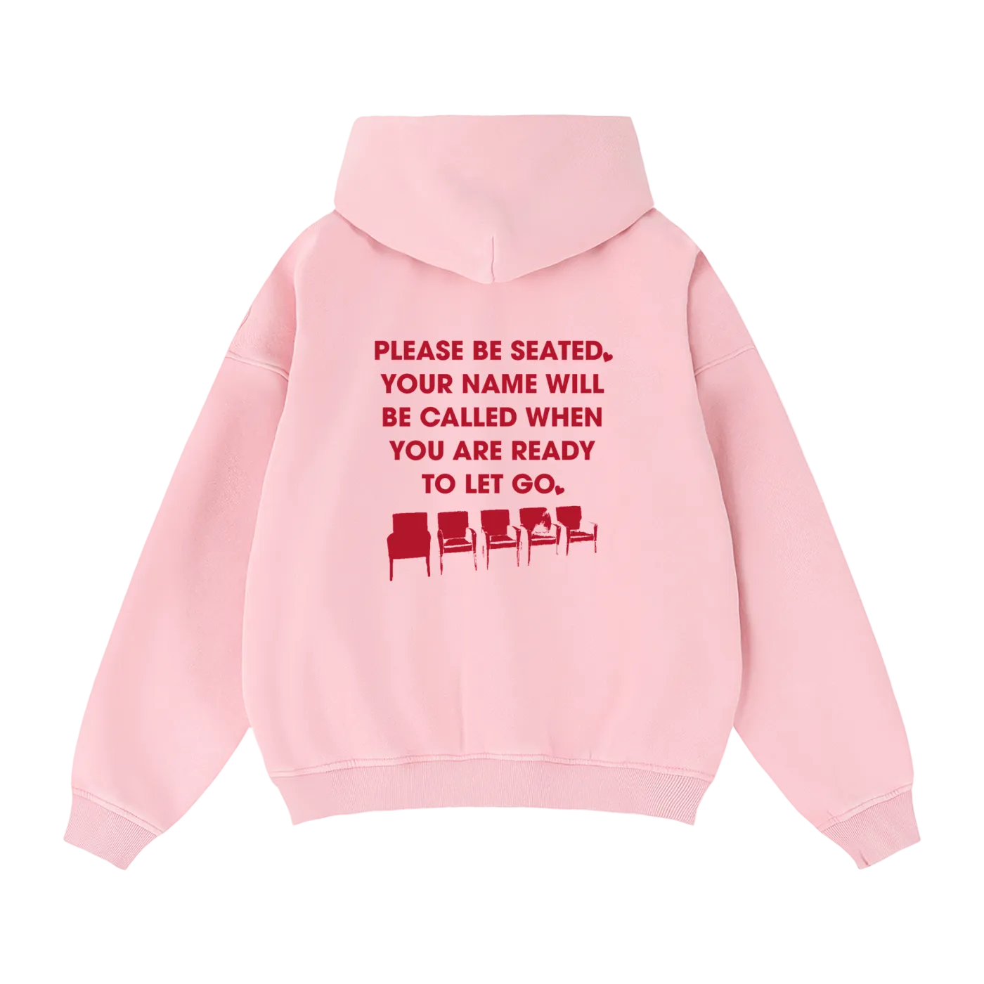 A light pink pullover hoodie shown from the back, featuring a red printed text graphic that reads 'PLEASE BE SEATED. YOUR NAME WILL BE CALLED WHEN YOU ARE READY TO LET GO.'